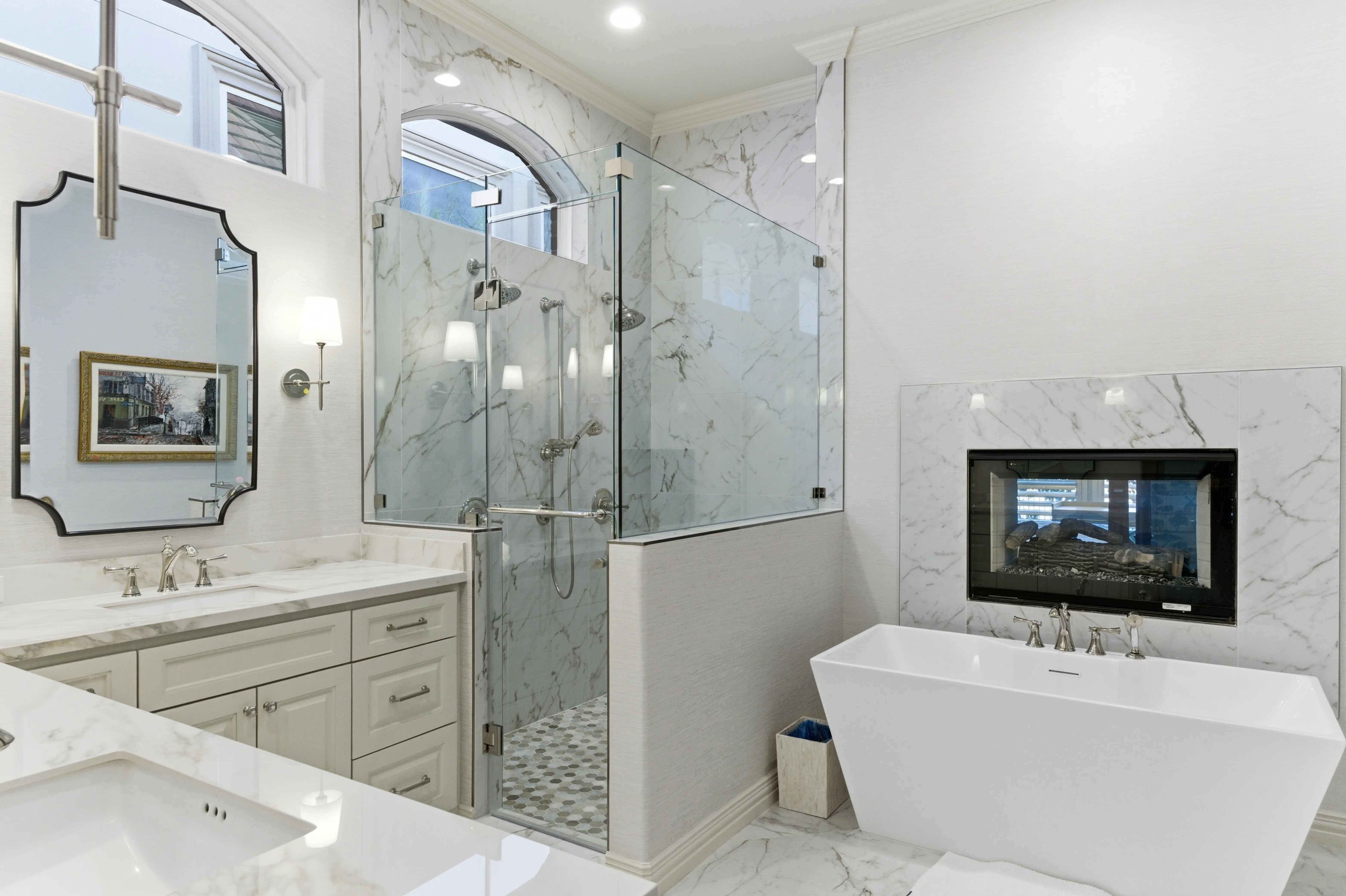 Primary bathroom freestanding soaking tub and faux Carrara marble porcelain walk-in shower